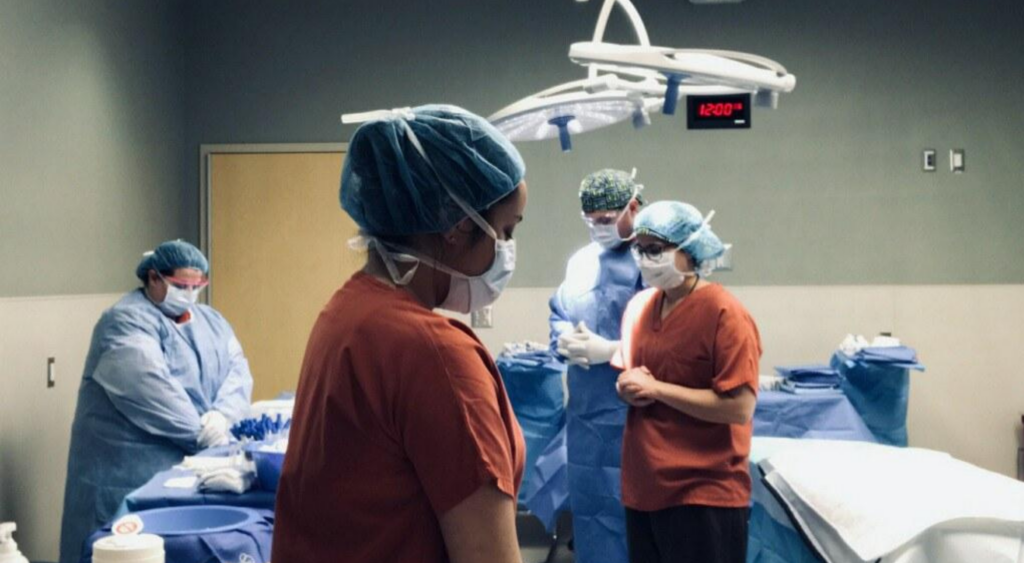 The tissue donation team in scrubs with their heads bowed for a moment of silence pre-surgery