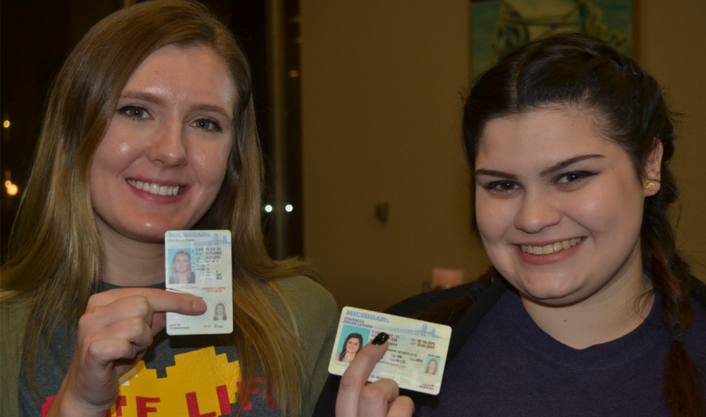 Two young women holding up driver's license