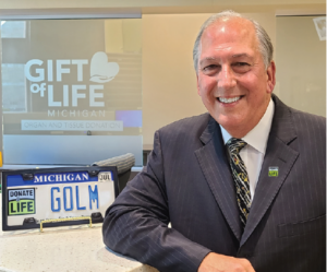 Man standing near framed Donate Life license plate