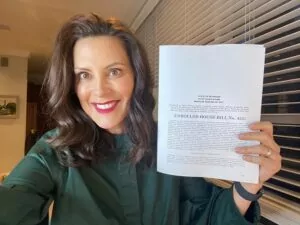 Governor Whitmer holding up the signed HOPE Act papers