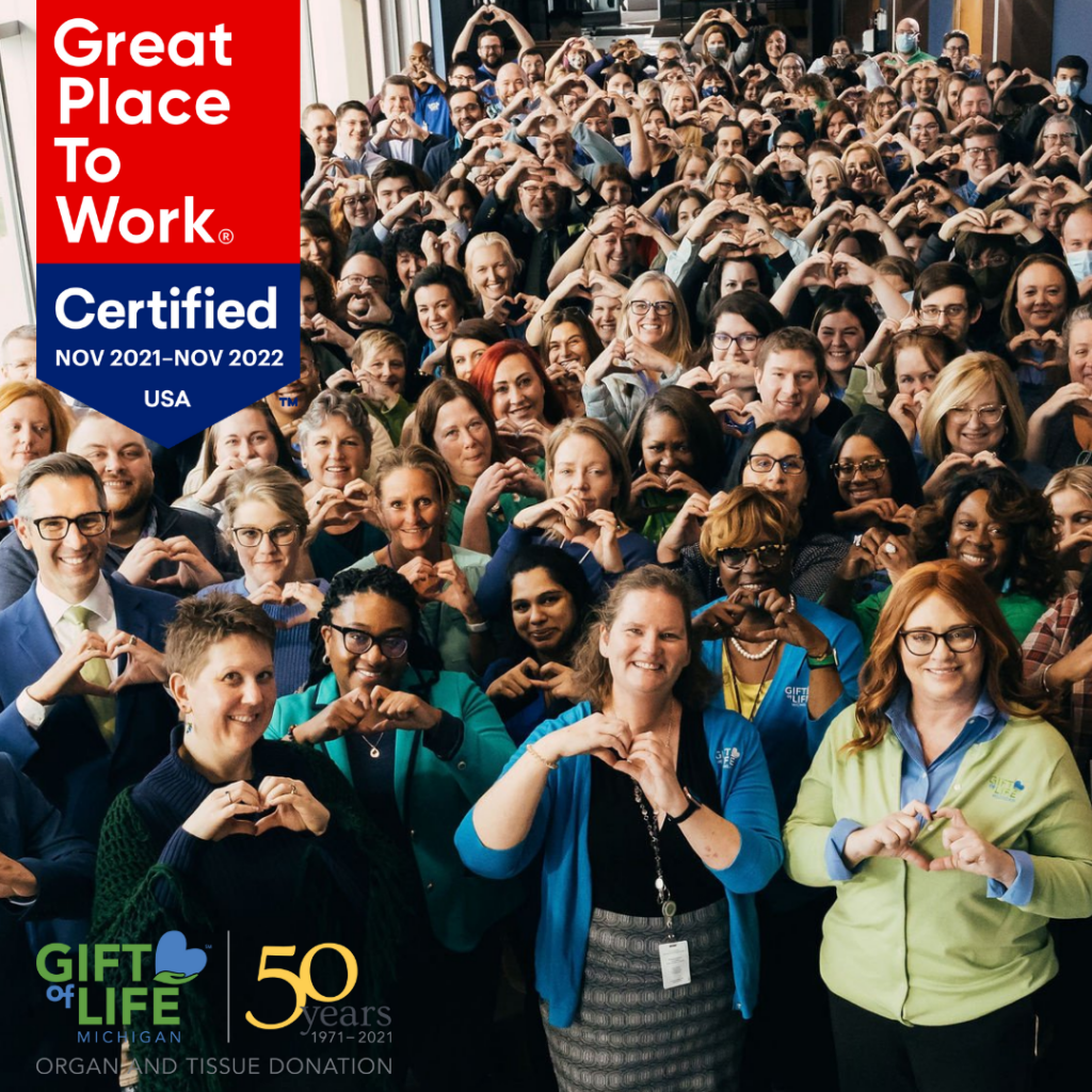 Large group of people with hands in shape of heart, Great Place to Work badge