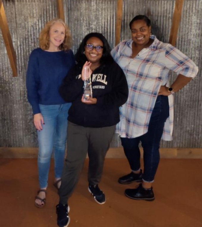 Three women holding award