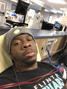Man sits in dialysis chair getting his blood cleaned by the machine