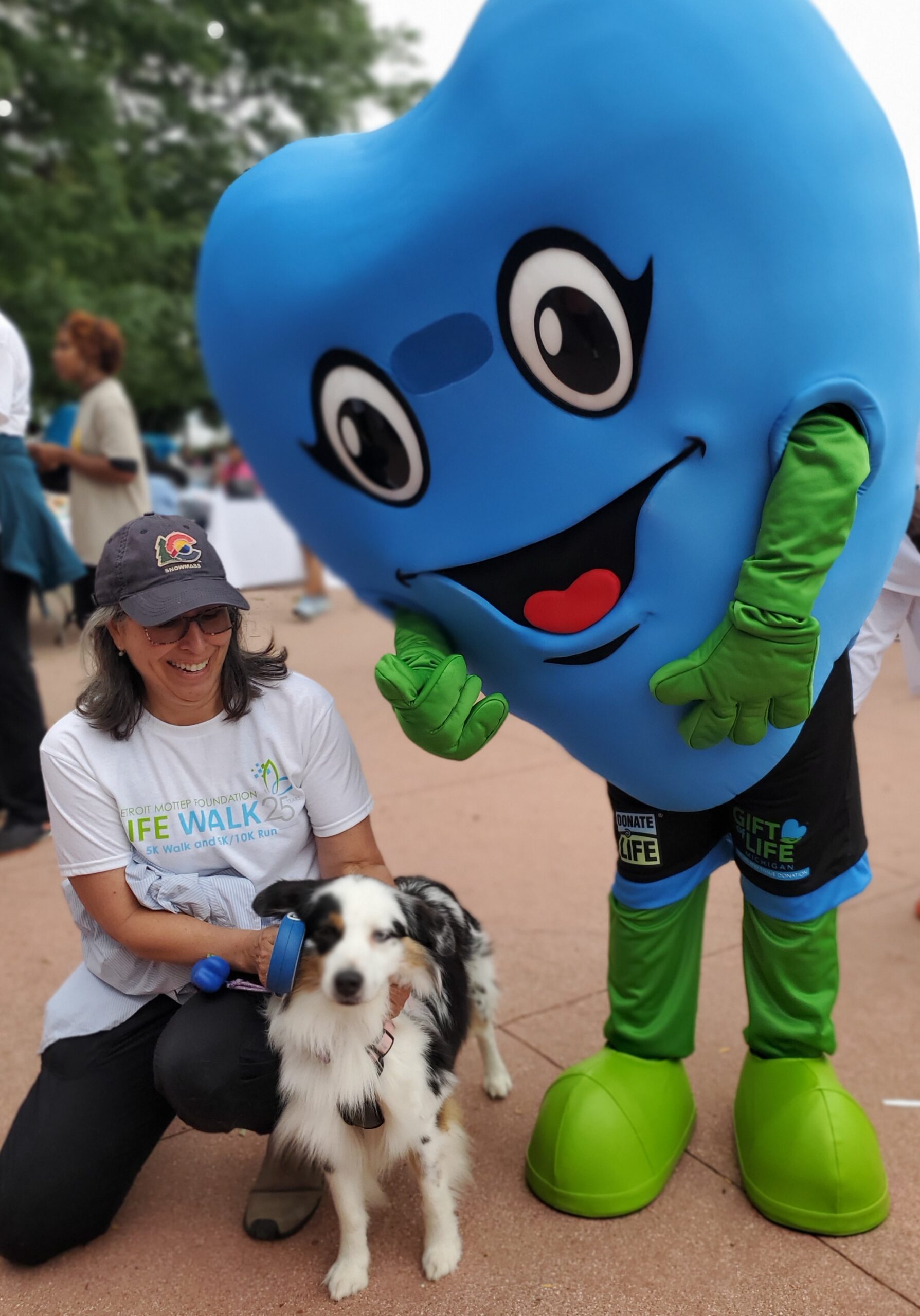 Gift of Life's mascot Hartley standing next to a woman and her dog.