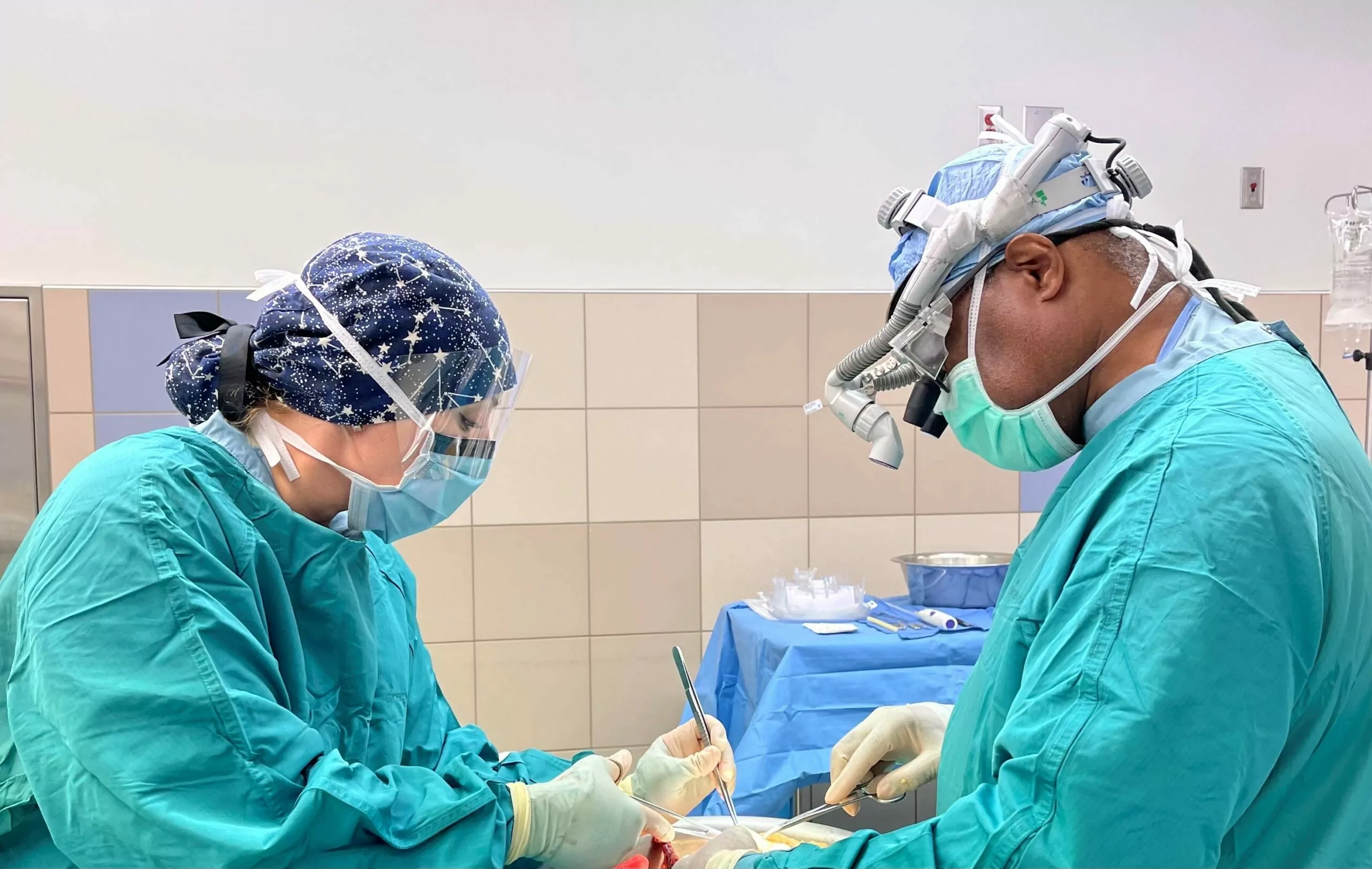 Recovery technicians and transplant surgeon in the operating room, holding surgical instruments