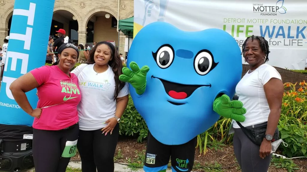 Three women around Hartley, Gift of Life's giant blue heart mascot