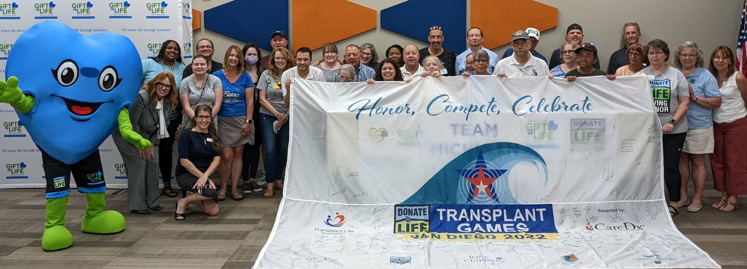 Group photo of Team Michigan holding up the autographed Transplant Games of America flag