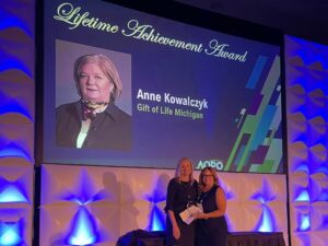 Dorrie Dils, President & CEO, accepts the award on Anne's behalf at the AOPO annual meeting