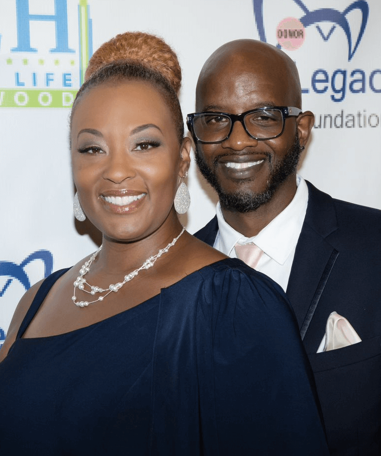 Woman and man in dress and suit, standing in front of Donate Life Hollywood step & repeat