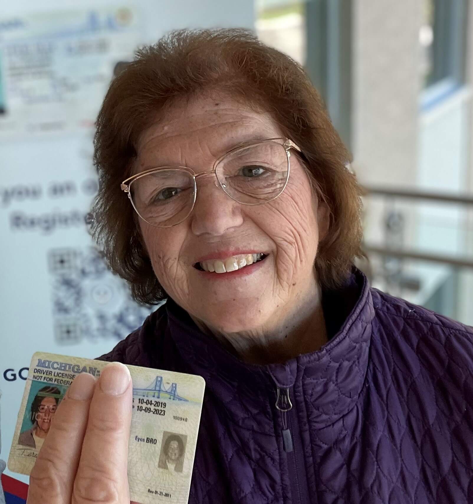 Elderly white woman holding up driver's license, there is no donor heart symbol