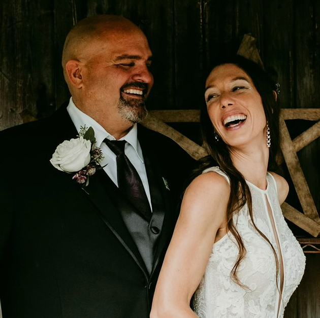 Man and woman in their wedding attire, laughing together