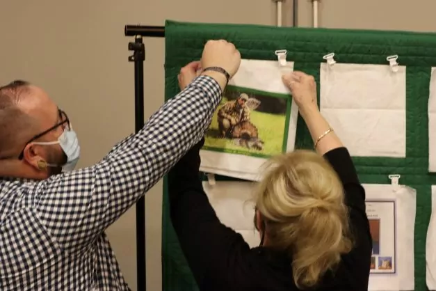 A couple pins a quilt square up, which they personalized in memory of their loved one who was an organ, tissue or eye donor.