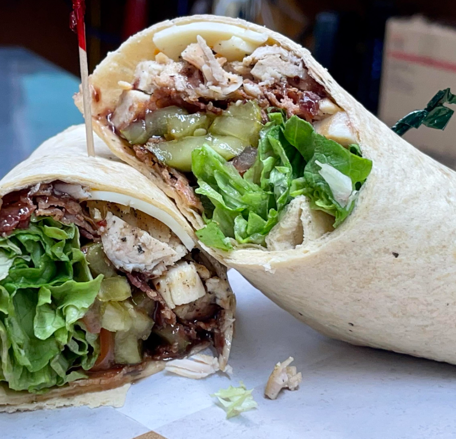 The "Lifesaver Wrap" pictured, including fresh grilled chicken, hickory smoked bacon, pepper jack cheese, blackberry Dijon, tropical rum glaze, sweet & spicy pickle chips, tomato and leaf lettuce all wrapped up in a flour wrap.