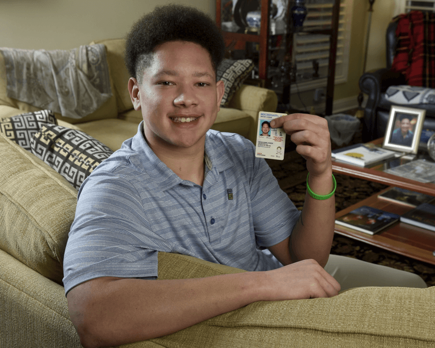 Tristan Johnson holds up his driver's license to show the organ donor designation.