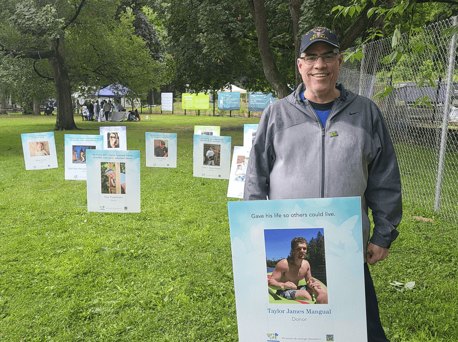 A man stands amidst the posters in the Circle of Life Trail at the John Ball Zoo.