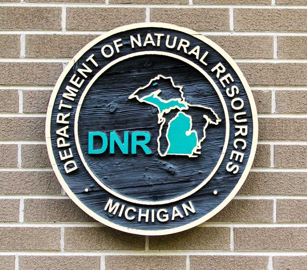 Michigan Department of Natural Resources logo sign on a brown brick wall
