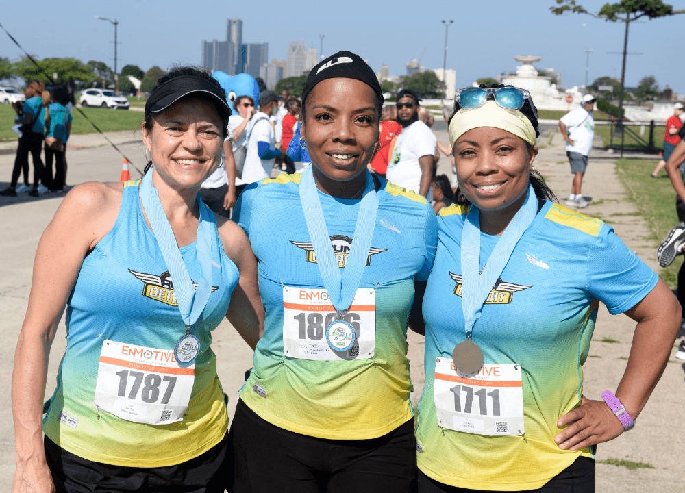 Run Detroit members wearing their runner medals at the finish line at LIFE Walk/Run 2023