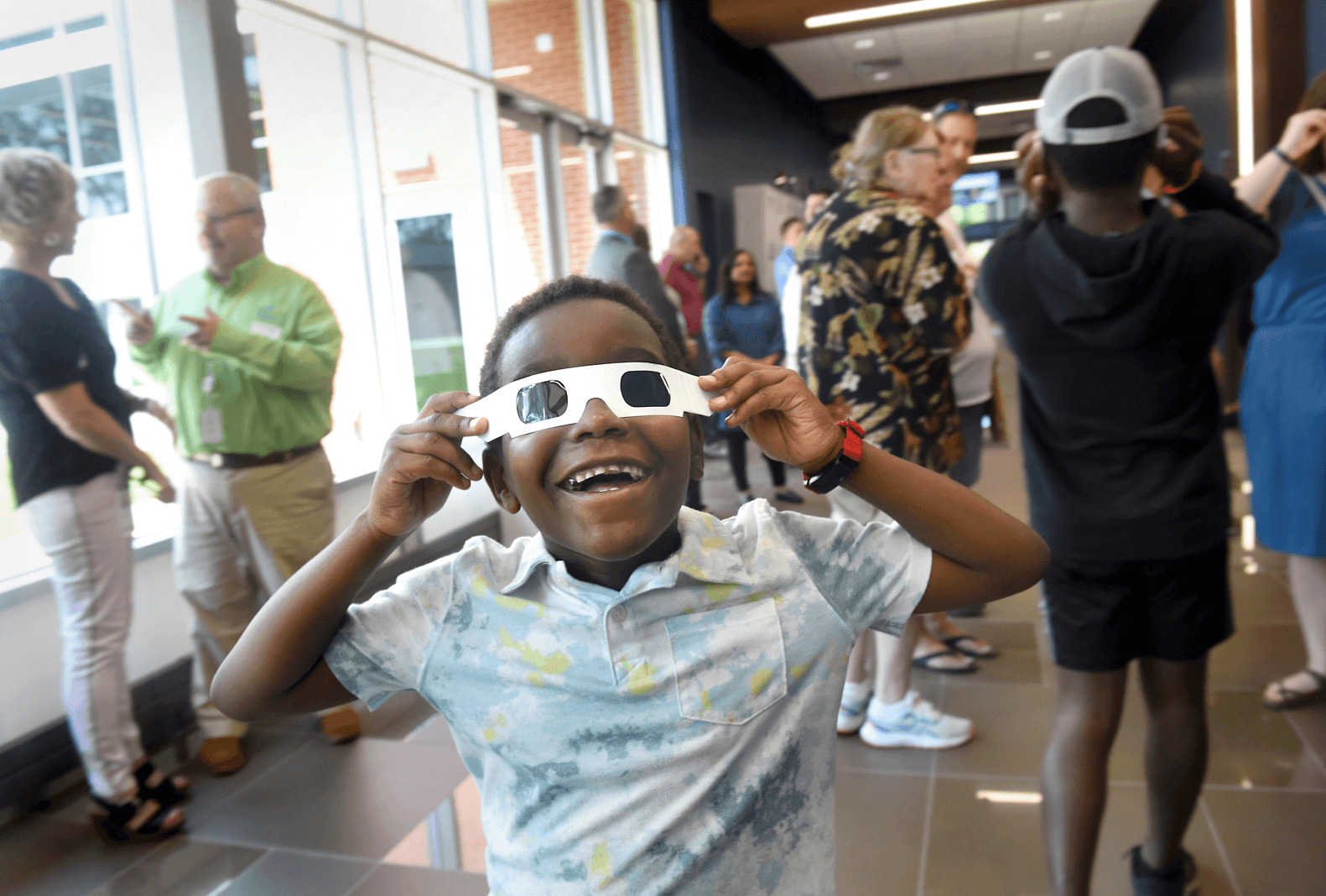 Young boy tries on a pair of glasses that mimic the need for a cornea transplant