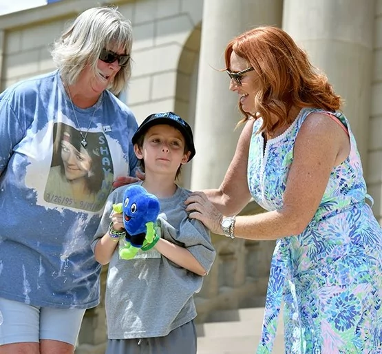 Gift of Life's President & CEO Dorrie Dils greets Deb Wyant and young Ollie on the Capitol steps. Ollie is holding a stuffed Hartley doll.