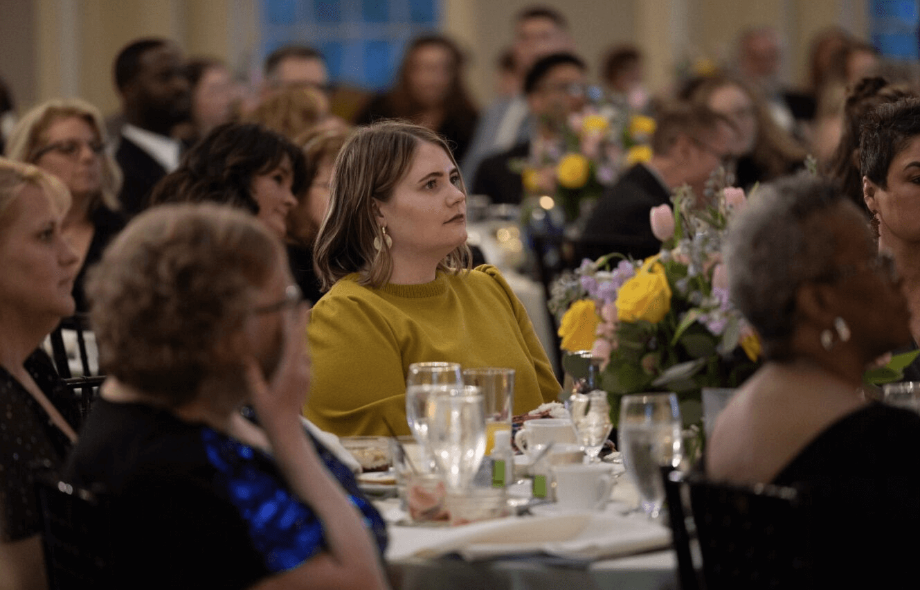 A group of well-dressed guests at a fancy dinner.