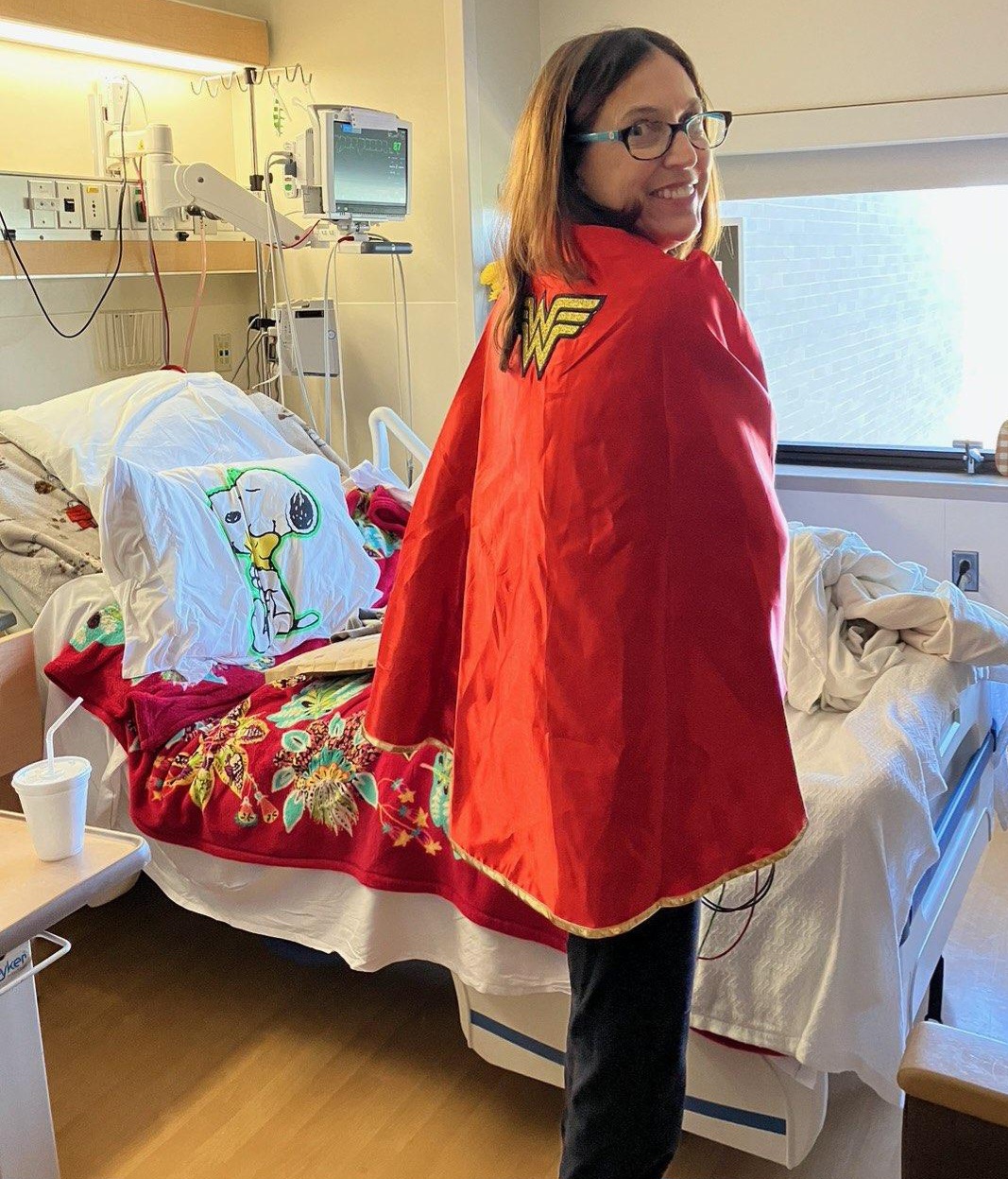 Sherry showing off her Wonder Woman cape in her hospital room