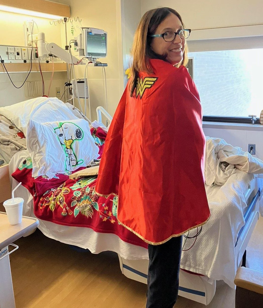 Sherry showing off her Wonder Woman cape in her hospital room