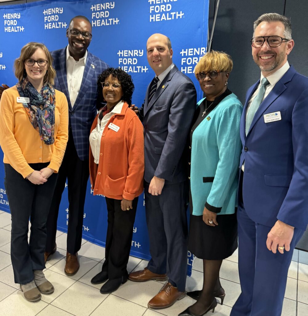 Devon Hagerman of the National Kidney Foundation of Michigan, Lieutenant Governor Garlin Gilchrist II, Cynthia Nichols-Jackson of the National Kidney Foundation of Michigan, SB-384 Sponsor Senator Kevin Hertel, Remonia Chapman and Patrick Wells-O'Brien of Gift of Life Michigan gathered in front of a Henry Ford Hospital step & repeat banner to celebrate the signing of Senate Bill 384, which protects the rights of living organ donors.