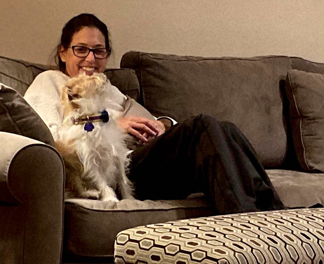 Sherry Johnson snuggles on the couch with her little dog, Lewis, after she returns home post- heart and kidney transplant.