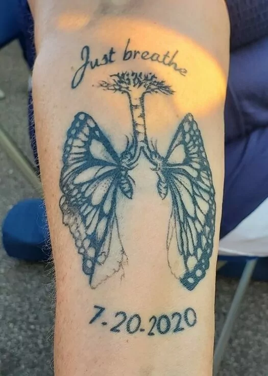 Tattoo of lungs made from butterflies reading "Just breathe" and the date 7-20-2020