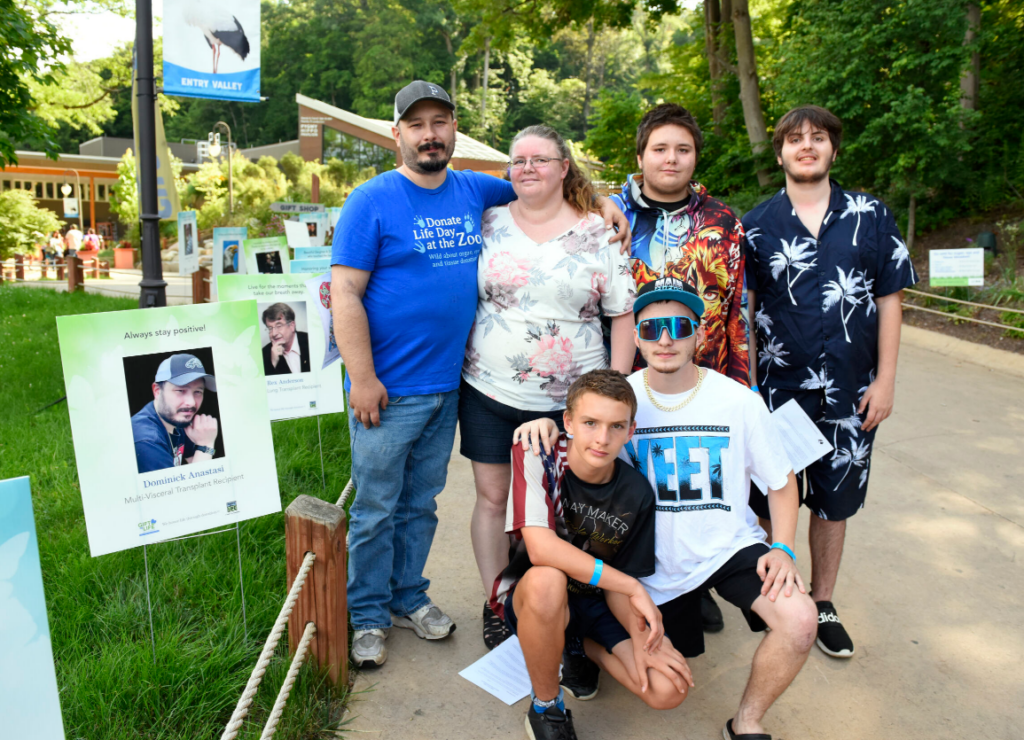 Dominic Anastasi and his family gather next to his poster on the Circle of Life Trail at Donate Life Night at the Zoo