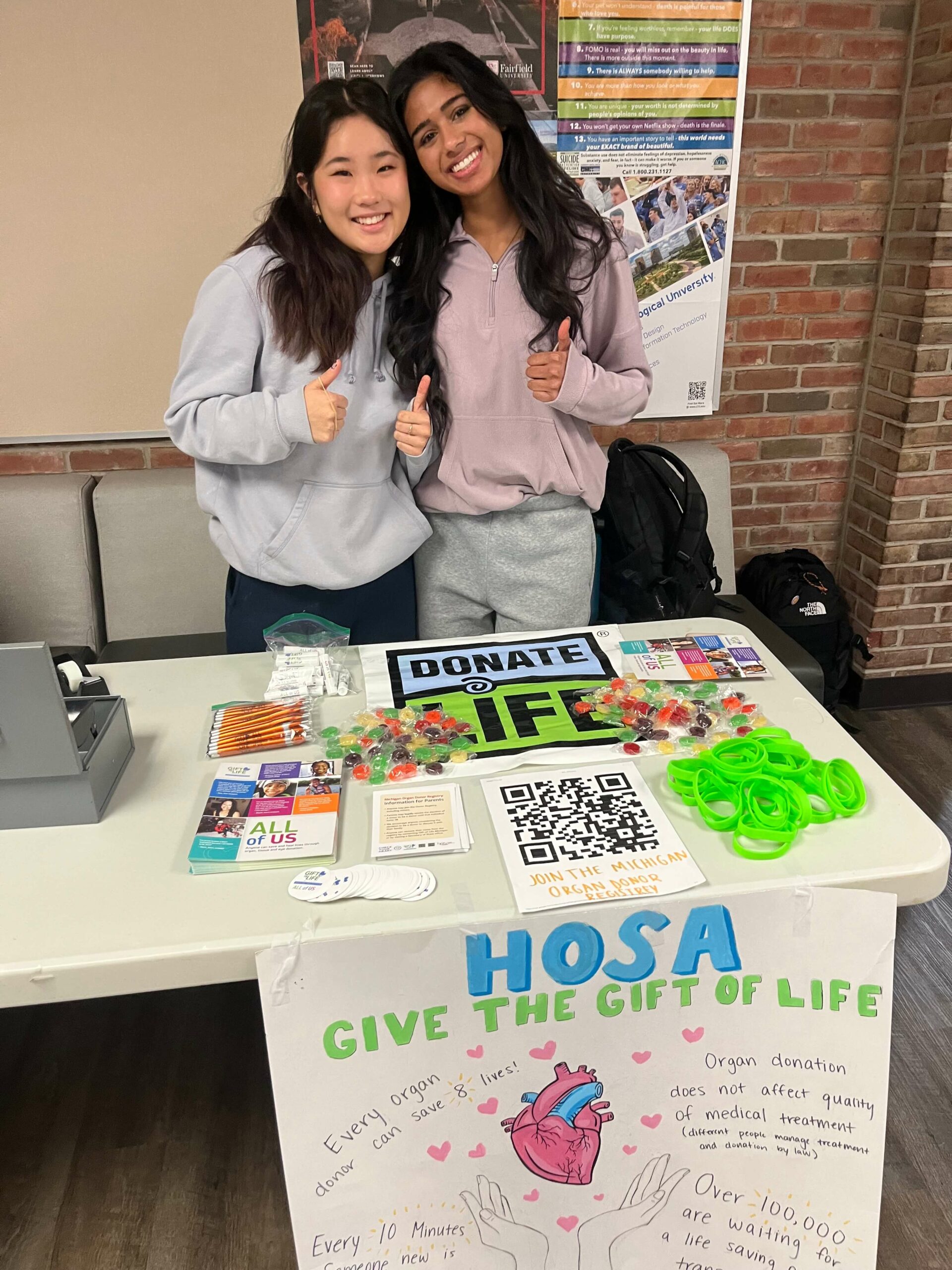 Two students standing behind an information table during the HOSA Challenge