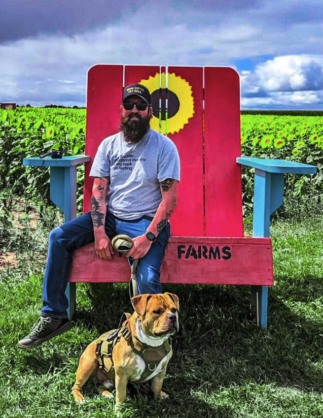 Richard "Jake" Jacobson and his dog at a sunflower farm