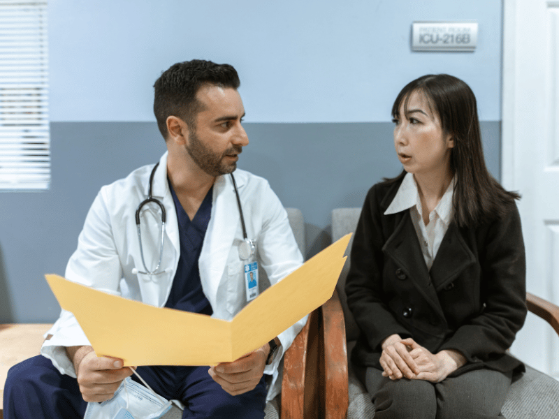 A physician consults with the family member of a patient.