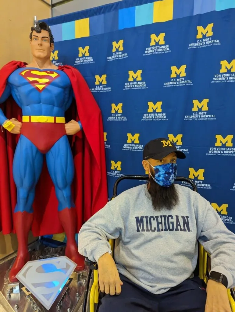 Richard "Jake" Jacobson  at Michigan Medicine in Ann Arbor with a Superman statue