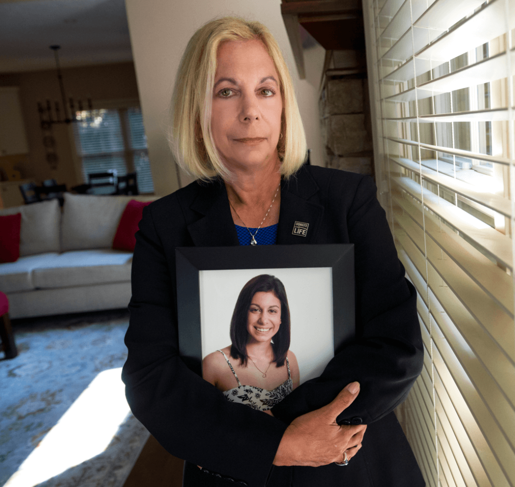 Donor mom Kathy Vogelsang holding a framed photo of her daughter, Rebecca