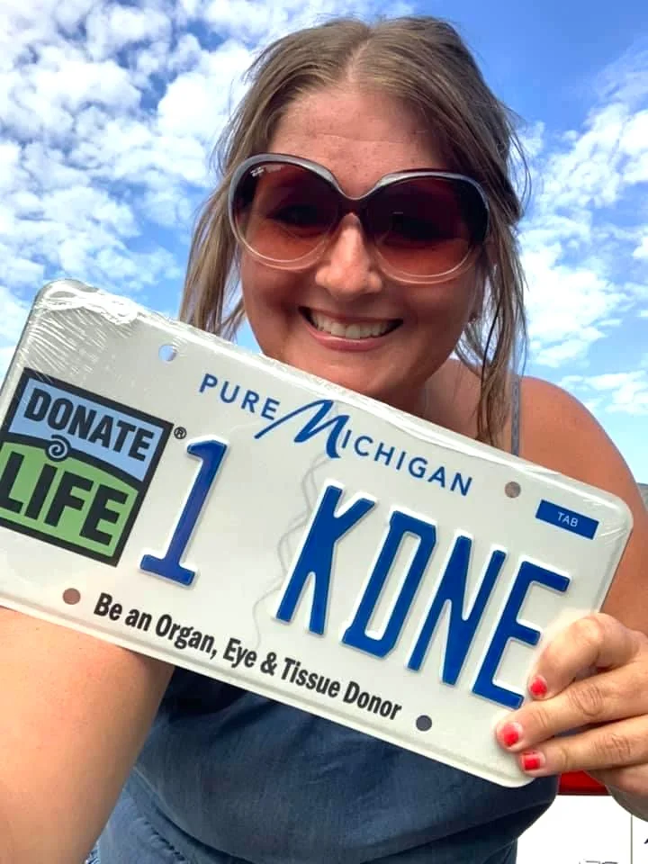 Sarah Jelsomeno holds up her Donate Life license plate