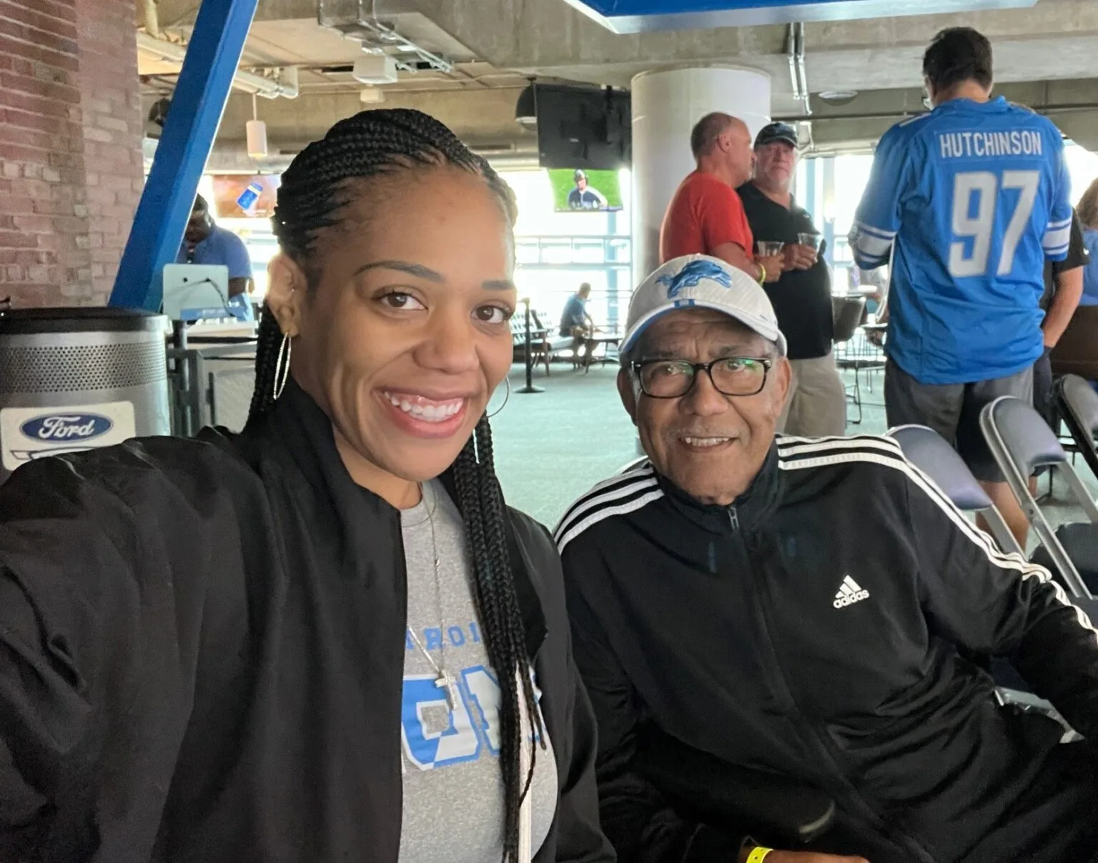 Jessica Bailey with her father, Deacon Lawrence Bailey, at a Detroit Lions game.