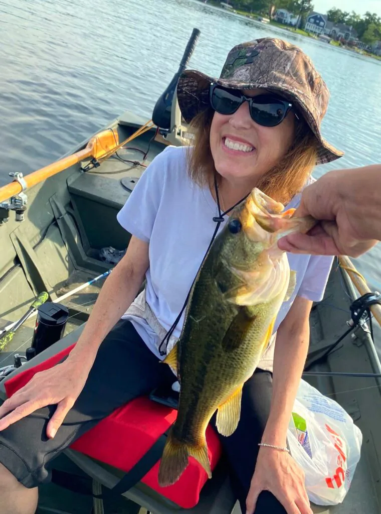 Sherry Johnson in a fishing boat, smiling about the fish that she caught.