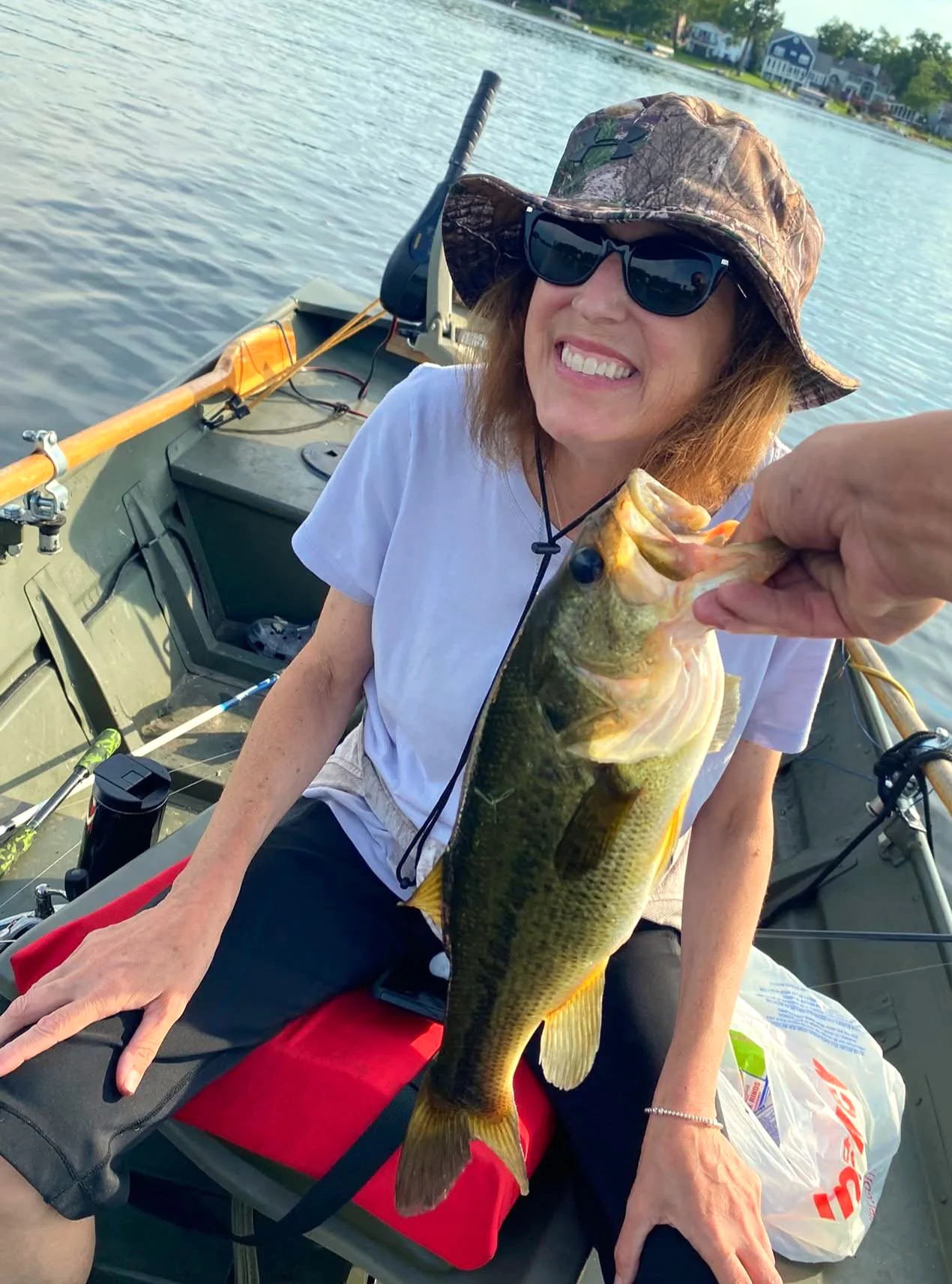 Sherry Johnson in a fishing boat, smiling about the fish that she caught.