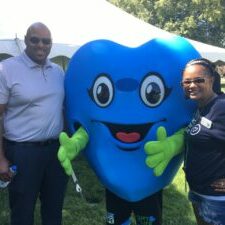 Mayor Ron Bacon, Hartley T. Heart (giant blue heart mascot) and Amy Bacon (heart transplant recipient) outdoors at the Capitol Rally in 2022.